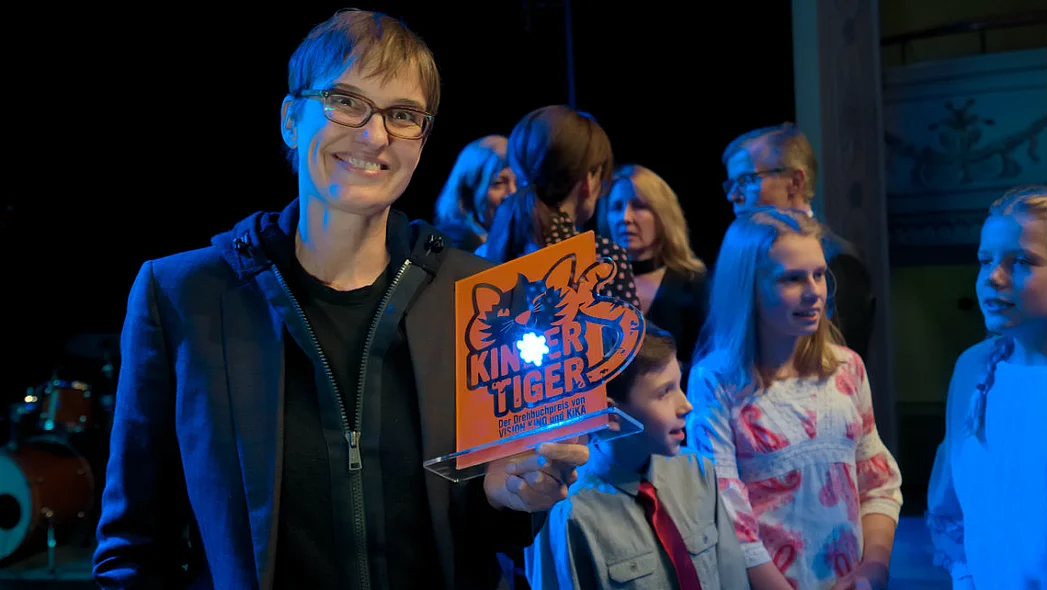 Preistr&auml;gerin Natja Brunckhorst mit der Kindertiger-Troph&auml;e, im Hintergrund Mitglieder der Kinderjury