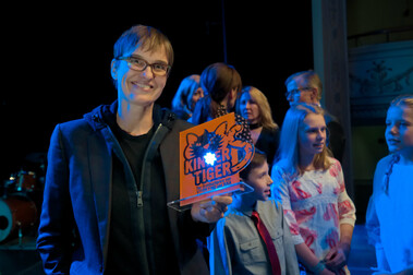 Preisträgerin Natja Brunckhorst mit der Kindertiger-Trophäe, im Hintergrund Mitglieder der Kinderjury