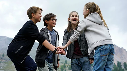 Szenenbild: die Pfefferkörner stehen im Kreis zusammen und legen in der Mitte die Hände aufeinander
