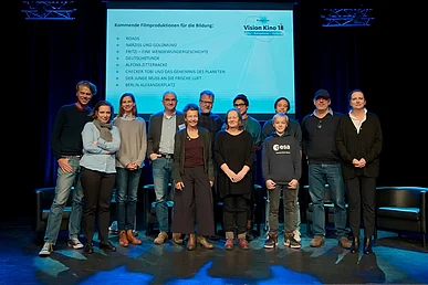 Vor der Leinwand mit Filmtiteln: Matthias Elwardt, Sarah Duve, Lydia Elmer, Ralf Kukula, Ruth Toma, Stefan Ruzowitzky, Burhan Qurbani, Tilman D&ouml;bler, Tobias Krell, Mark Schlichter, Nicole Kellerhals (v.l.n.r.)