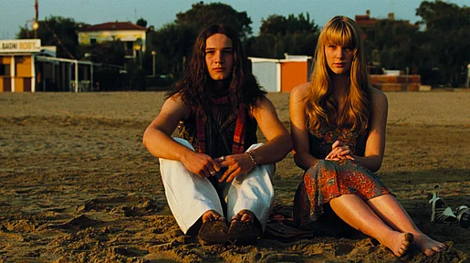 Szenenbild: Zwei Mädchen sitzen im milden Abendlicht auf einer Wiese