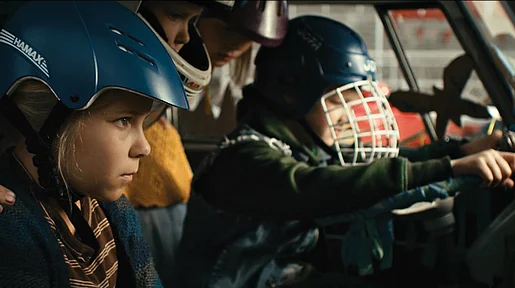 Szenenbild: Ella mit Helm, von der Seite gesehen, in einem Auto