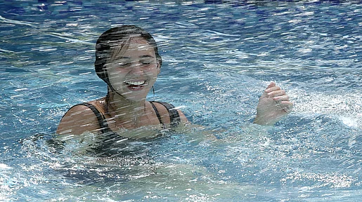 Szenenbild: Jessica im Pool mit Wasser spritzend