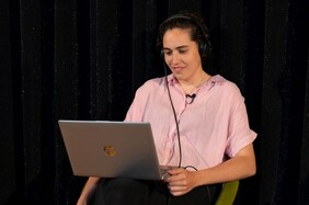 Joya Thome mit Kopfhörern und Laptop
