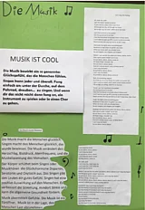 Gr&uuml;nes Plakat mit Titel "Die Musik" und vier Texten: "Musik ist cool", "Musik macht gl&uuml;cklich" und zwei Liedtexte