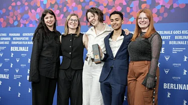 Drei Jury Mitglieder und die beiden Filmemacher*innen vor Berlinale Wand
