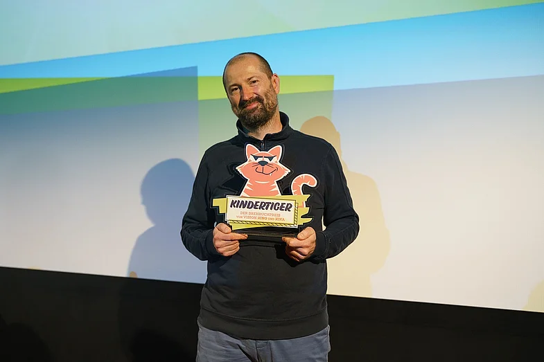 Winfried Oelsner mit der Preisstatue Kindertiger