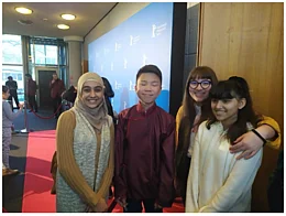 Drei Sch&uuml;ler:innen und ein Junge - der Hauptdarsteller des Films - im Foyer des Kinos