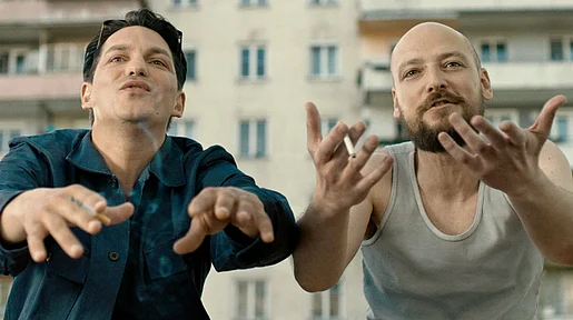Szenenbild: Benny und Marka in redseliger Pose und halbnaher Einstellung