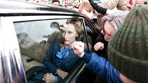 Szenenbild: Meryl Streep als Maggi Thatcher im Fond eines Autos inmitten einer wütenden Menschenmenge