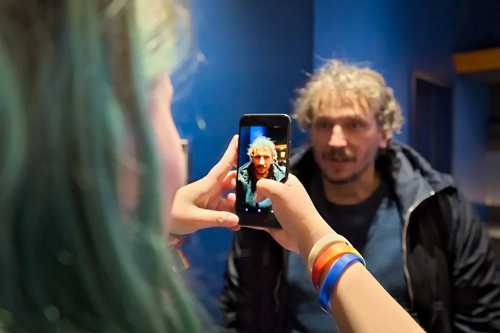 Laura Langanke nimmt Marcus H. Rosenm&uuml;ller mit den Handy auf