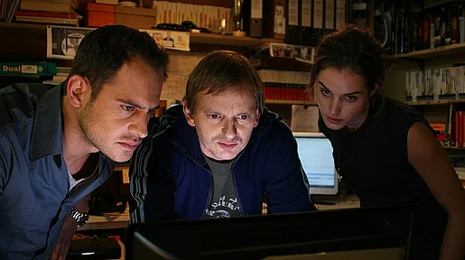 Szenenbild: Drei junge Menschen starren auf einen Bildschirm
