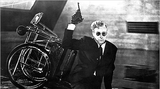 Szenenbild: Peter Sellers als Dr. Seltsam mit einer Waffe vor seinem umgekippten Rollstuhl sitzend