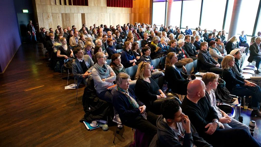 Blick auf die gef&uuml;llten Reihen im gro&szlig;en Saal des KOMED K&ouml;ln w&auml;hrend einer Podiumsdiskussion