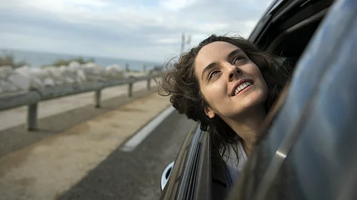 Szenenbild: Sonia steckt während einer Autofahrt ihren Kopf durchs Fenster