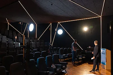 Kinosaal mit Kamera- und Lichtstativen