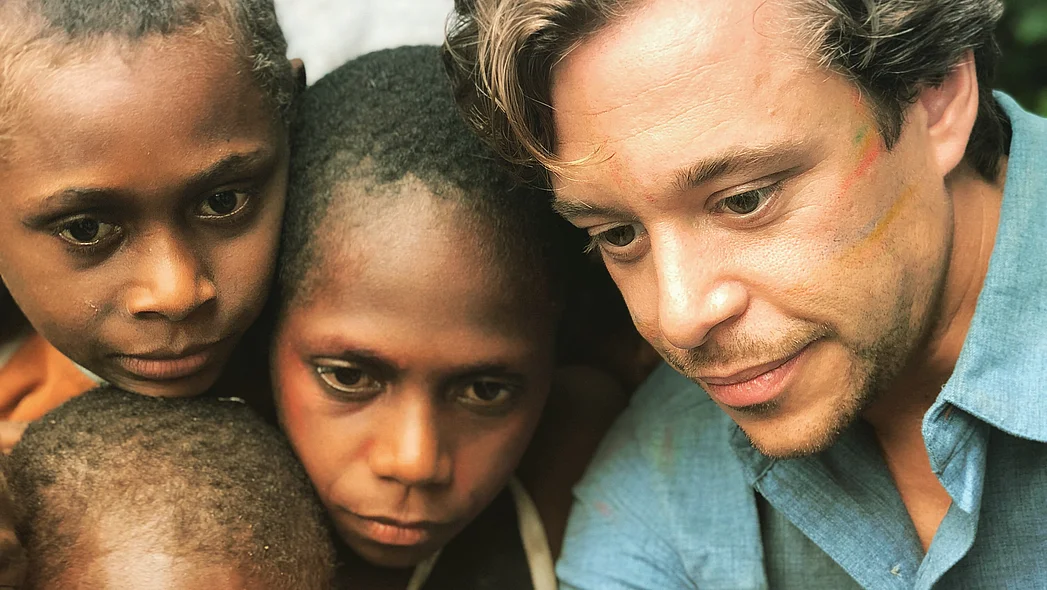 Checker Tobi mit ein paar dunkelh&auml;utigen Kindern.