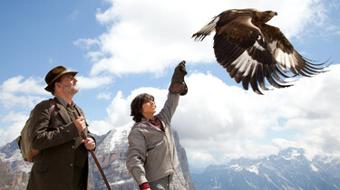 Szenenbild: Förster Danzer und Lukas warten auf den Adler, der im Anflug ist. Lukas hat die Hand zum Landen ausgestreckt