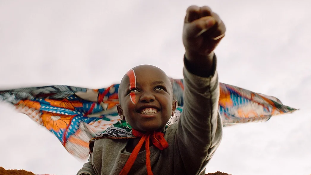 Jo in eine Superheldenpose mit geballter Faust und ausgestrecktem Arm, fertig zum Abflug.