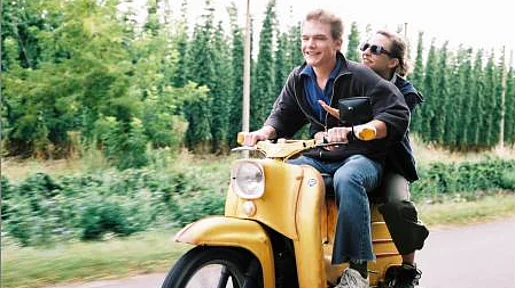 Szenenbild: Annika und ein junger Mann auf einem gelben Motorroller