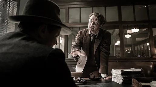 Szenenbild: Jude Law als Tom Wolfe aufgebracht am Schreibtisch seines Lektorss