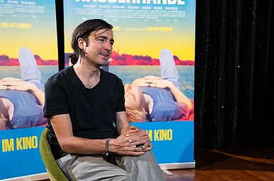 Regisseur Ilker &Ccedil;atak vor Plakaten R&Auml;UBERH&Auml;NDE