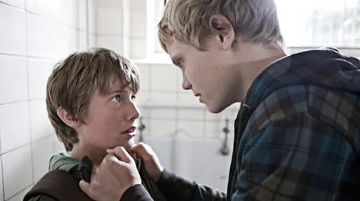 Szenenbild: Ein blonder Junge packt einen kleineren JUngen am Kragen