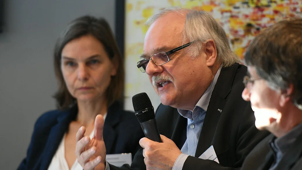 Bild von Podiumsteilnehmer Horst Niesyto mit Mikrofon, im Hintergrund weitere Teilnehmende