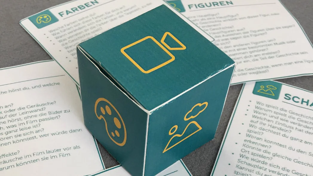 fertig gebastelter W&uuml;rfel und ausgeschnittene Fragekarten