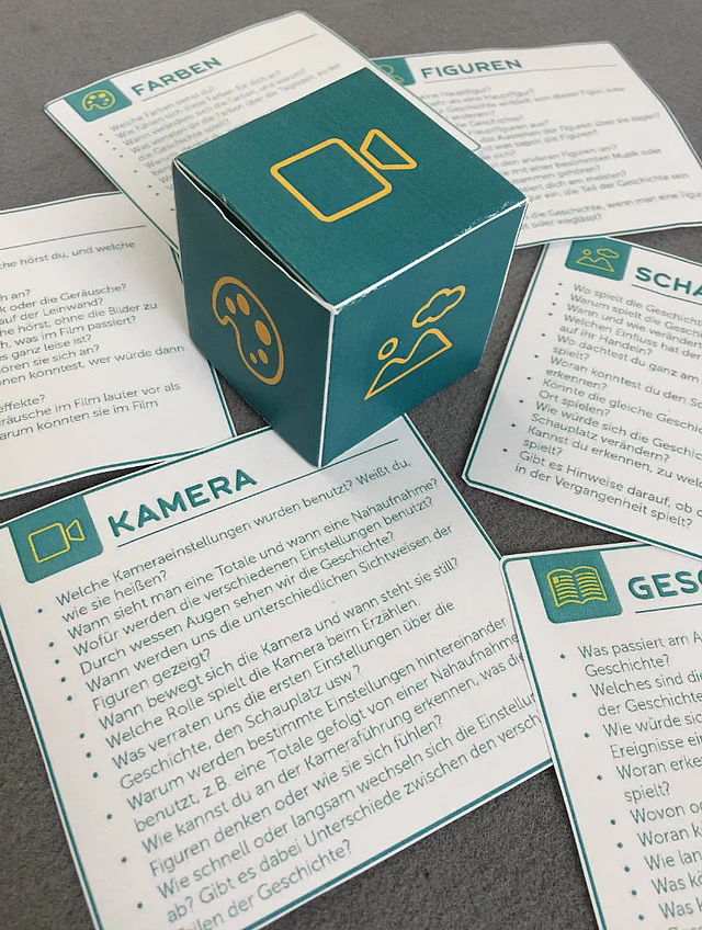 fertig gebastelter W&uuml;rfel und ausgeschnittene Fragekarten