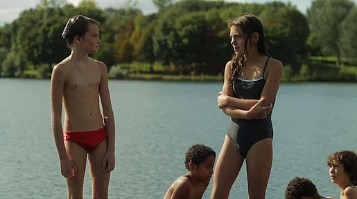 Szenenbild: Laure/Michael in Badehose, neben ihr/ihm ein Mädchen im Badeanzug