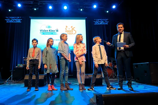 Blick auf die B&uuml;hne, auf der Moderator Tim Gailus gerade die Kinderjury befragt