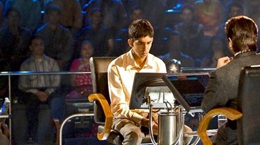 Szenenbild: Der Moderator der Quizshow "Wer wird Millionär?" in Mumbai und sein Gast Jamal