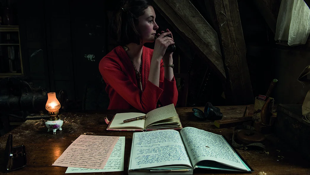 M&auml;dchen sitzt im Dunkeln mit Tagebuch vor ihr