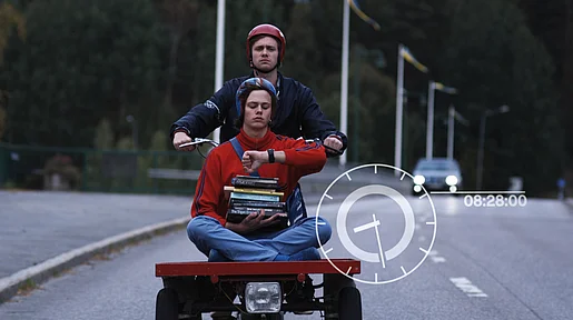 Die beiden Brüder Simon und Sam fahren mit einem motorisiertem Rad die Straße hinab. 