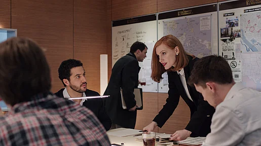 Szenenbild: Miss Sloane in Arbeitssituation mit Kollegen, an einem Tisch stehend