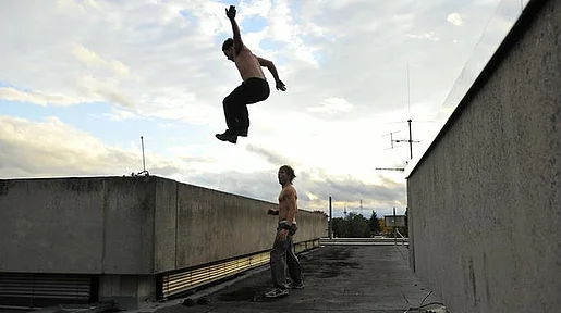 Szenenbild: Der junge Gerüstbauer Richie und ein Freund beim Parkour
