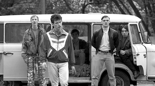 Szenenbild: Die Gruppe junger Männer an einem VW-Bus