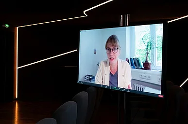 Bild von Dr. Astrid S&eacute;ville auf einem gro&szlig;en Bildschirm