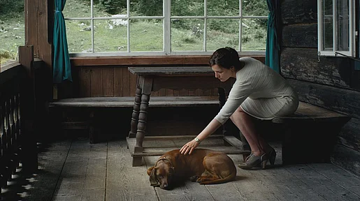 Szenenbild. Die Frau und der Hund auf der Veranda des Hauses