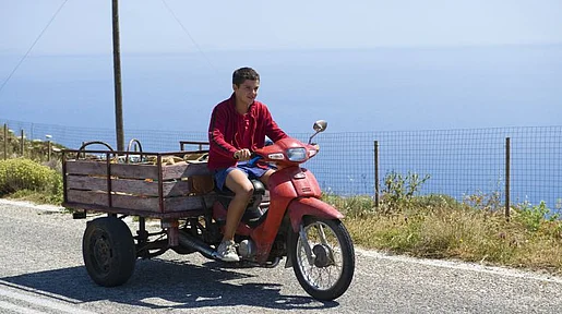Szenenbild: Yannis auf einem Moped mit Anhänger