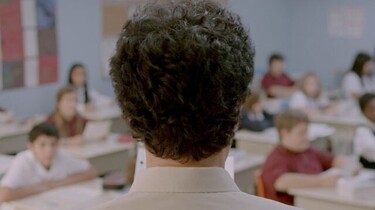 Szenenbild: Der Kopf von Monsieur Lazhar von hinten, im Hintergrund ist die Schulklasse zu erkennen