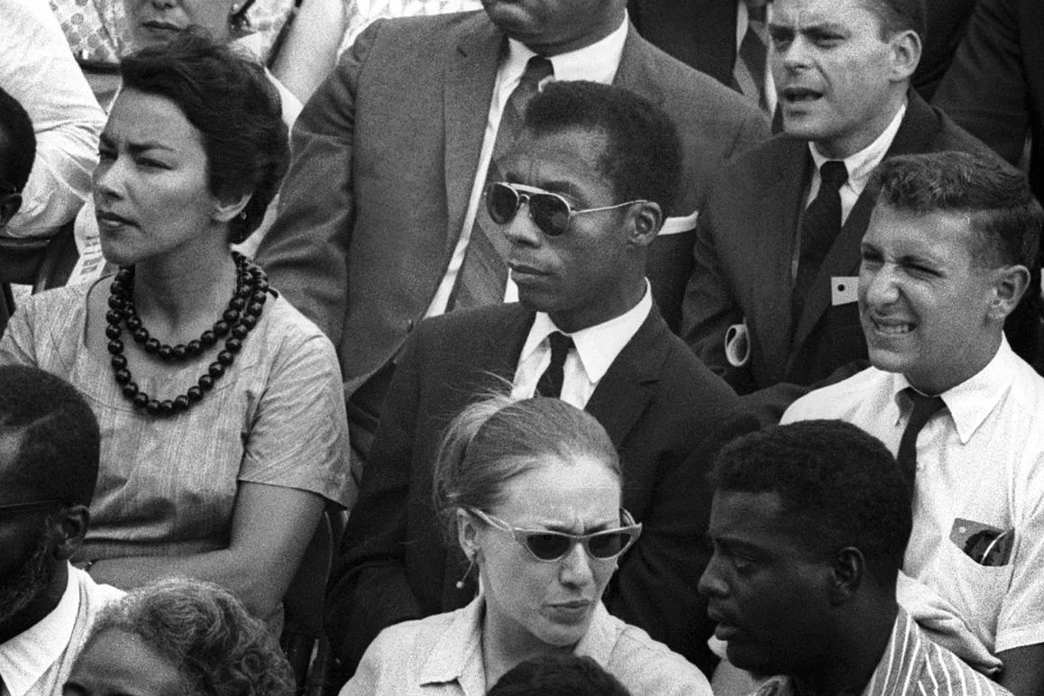 Szenenbild: James Baldwin sitzend in einer Zuschauermenge