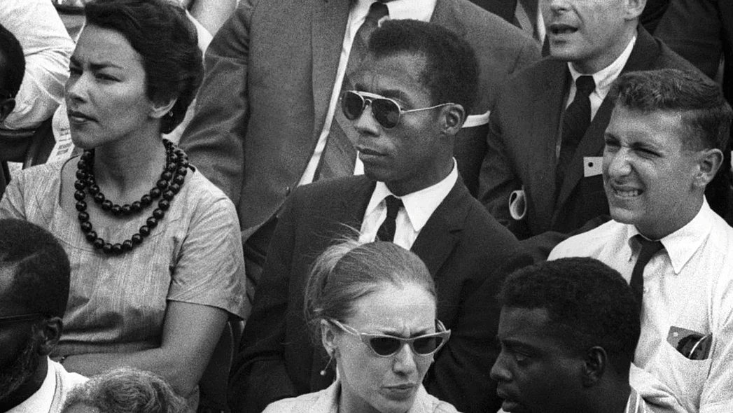 Szenenbild: James Baldwin sitzend in einer Zuschauermenge