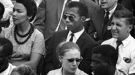 Szenenbild: James Baldwin sitzend in einer Zuschauermenge