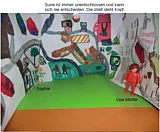 Zwei Playmobilfiguren (beschriftet mit "Sophie" und "Opa Morfar") und eine dritte Figur kopf&uuml;ber, vor einem gemalten Hintergrund 