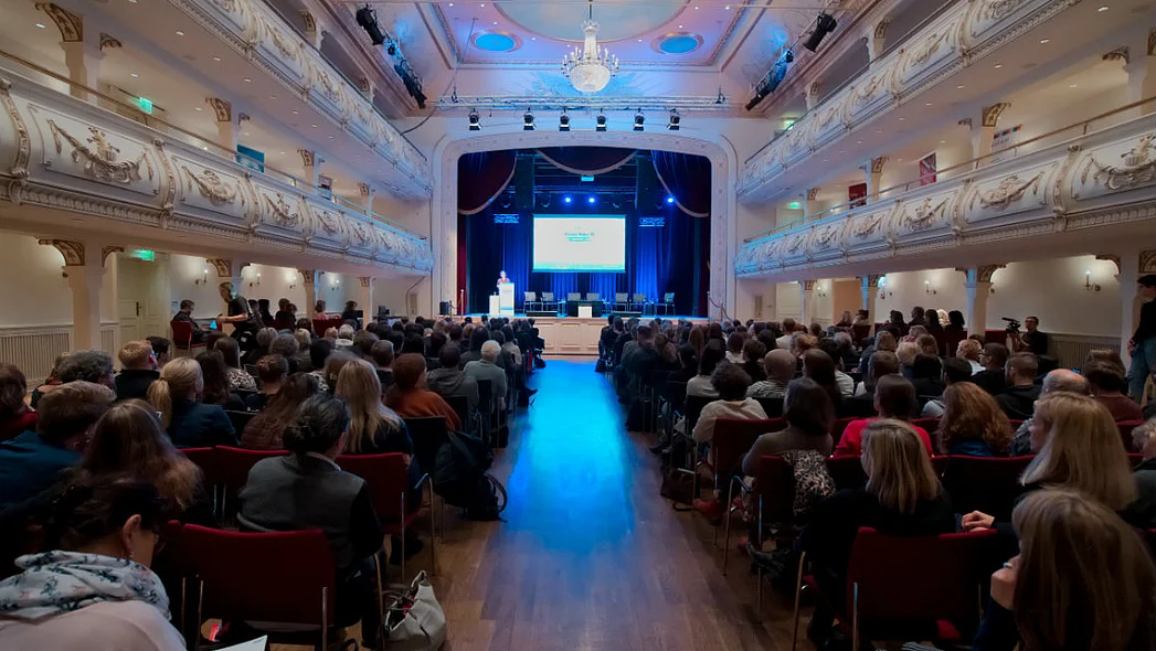 Kaisersaal, voll besetzte Stuhlreihen und Blick zwischen den Reihen auf die B&uuml;hne