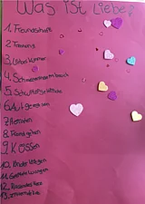 Ein rosa Plakat zu der Frage "Was ist Liebe?"