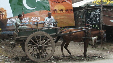 Szenenbild: Ein Pferd zieht eine sehr einfach Kutsche mit zwei Männern