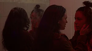 Zwei Frauen sehen sich in der N&auml;he eines Spiegels an.